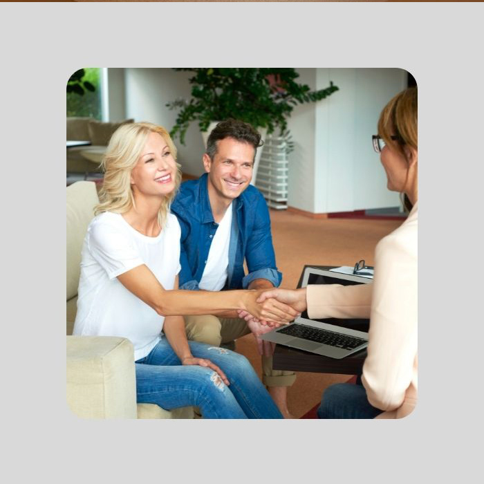 A man and woman shaking hands with a sales person.