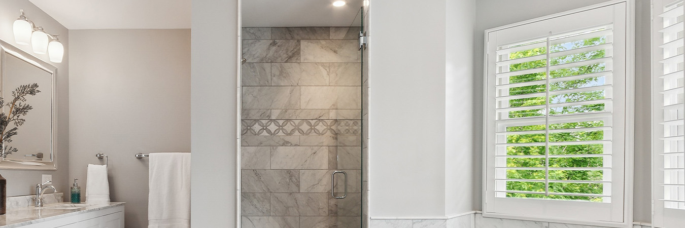 White and gray bathroom with several small white Polywood shutters.