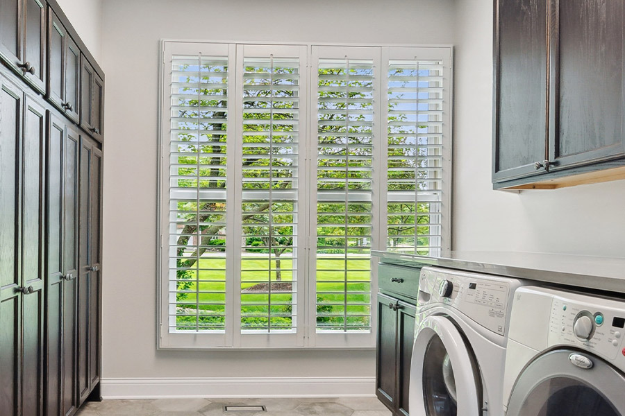 Find the perfect level of natural light for your New Brunswick laundry room with interior shutters. White Polywood shutters letting light through a laundry room window