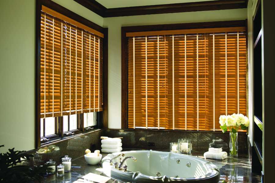 Premium quality blinds are always a stylish accent in your New Brunswick home. Brown wood blinds on large windows in a green bathroom