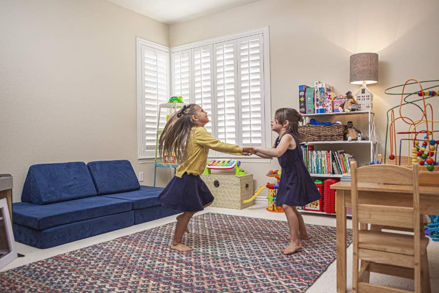 Choose Polywood shutters for durable, kid-friendly great room window treatments in New Brunswick. Polywood shutters on multiple windows in a sitting area