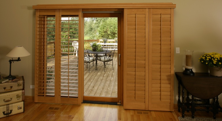 Wood shutters create a buffer that transitions from indoor wood to patio. New Brunswick wood shutter sliding door