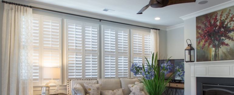 Polywood shutters can be custom made to fit any specialty window type. Polywood shutters in a living room.