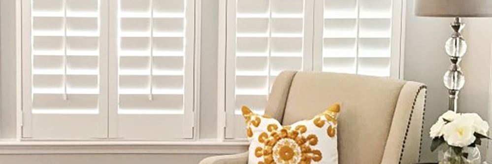 White interior shutters filtering light into a living room