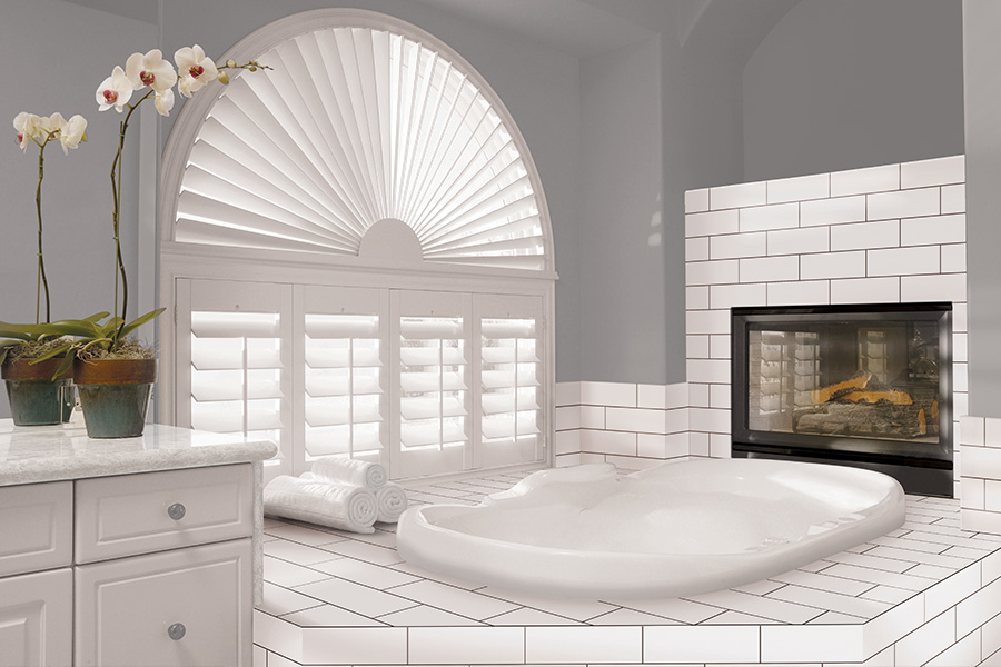 Explore our selection of window treatments for builders in New Brunswick to find the perfect ones for your next construction project. White Polywood shutters on an arched bathroom window