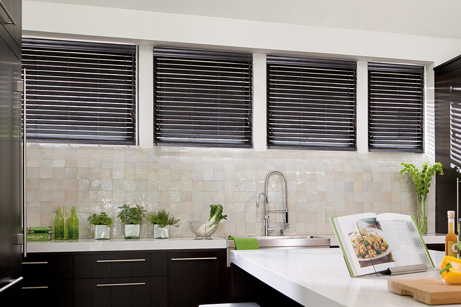Choose custom Polywood faux wood blinds for your kitchen in New Brunswick. Special shaped faux wood blinds in several windows above a sink.