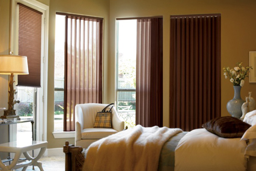 Choose durable and high-quality fabric or vinyl vertical blinds in New Brunswick. Maroon fabric vertical blinds inside a bedroom