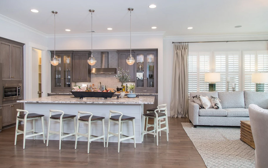 Illuminate your home with custom interior shutters in New Brunswick. White arched shutters in a white kitchen with lots of light.