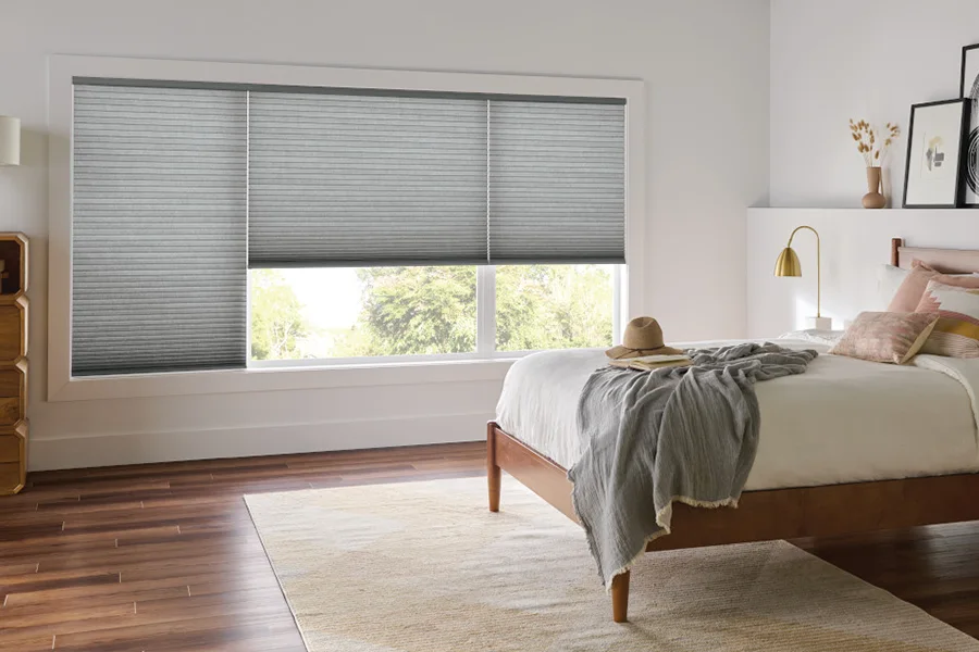 ash gray cellular shades on three large windows within a modern farmhouse style bedroom