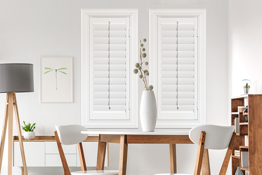 Sunburst's selection of stylish window treatments for designers in New Brunswick makes it easy to find the perfect ones for every design job.  White Polywood shutters on two windows in a modern Scandinavian-style room