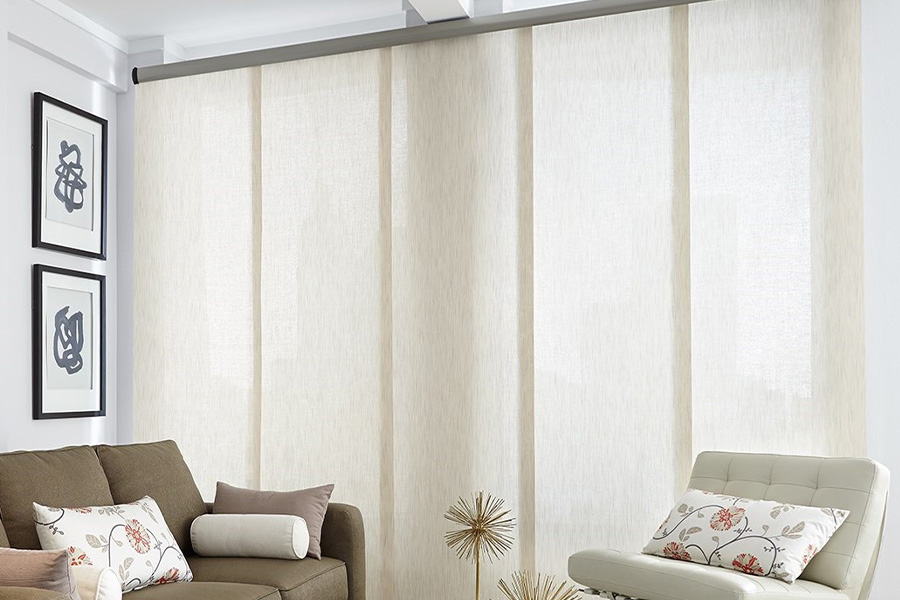 Find window treatments to complete any interior design among our extensive selection at Sunburst Shutters New Brunswick.  Long off-white window shades on a tall window in a modern living room