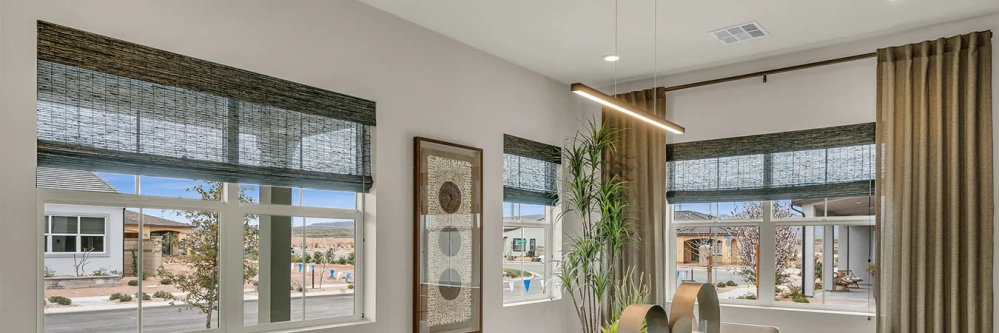Brown woven shades pulled halfway down over dining room windows