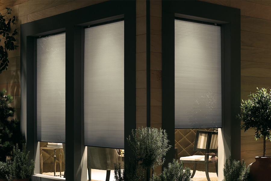Cellular shades are modern and stylish window treatments for your home in New Brunswick. Dark gray cellular shades displayed from the exterior of a home.