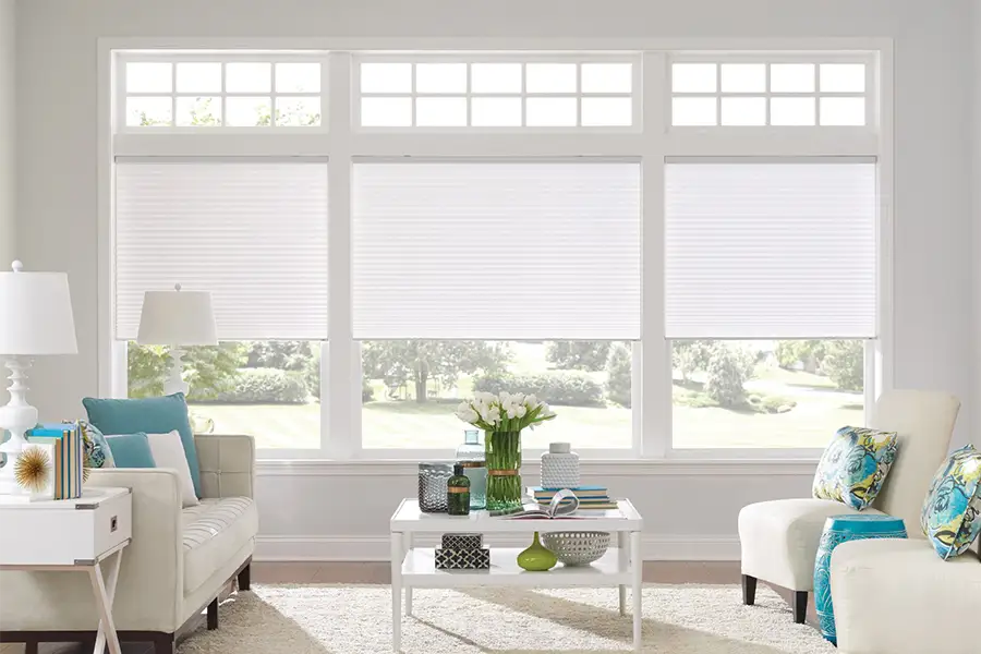 White cellular shades on windows in a white living room
