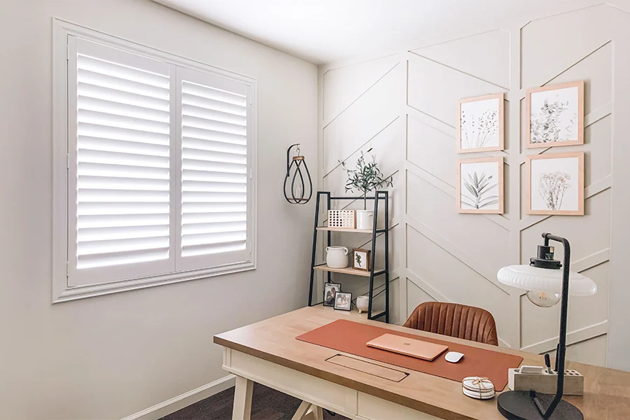 You'll never get too hot or cold while working with energy-efficient Polywood shutters in your office. White Polywood shutters on a home office window