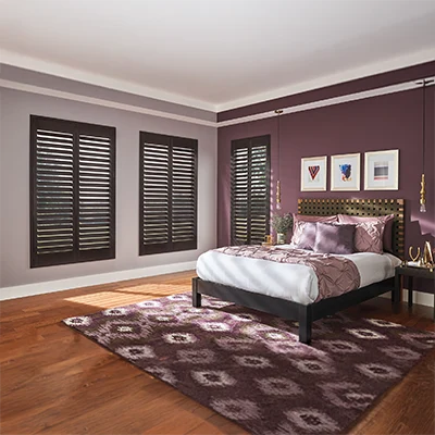Dark brown ovation shutters in a corner of a bed room