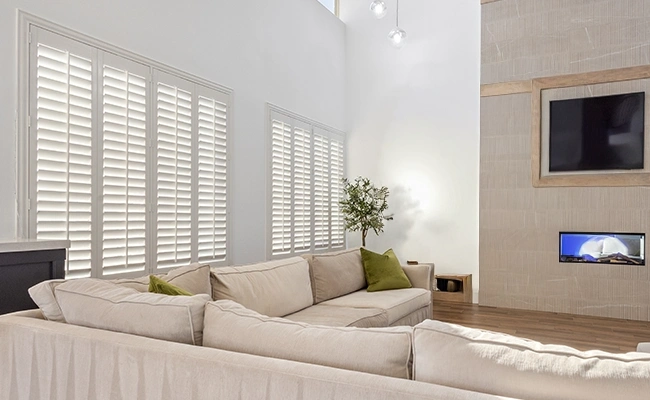 white polywood shutters in a large beige decorated living room